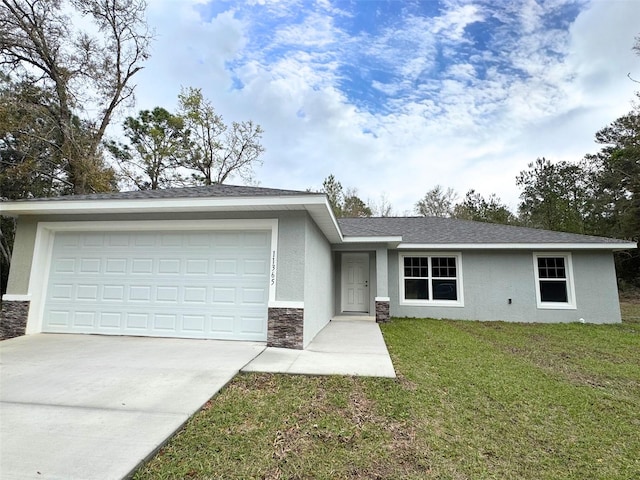 single story home with concrete driveway, a front yard, stucco siding, stone siding, and an attached garage