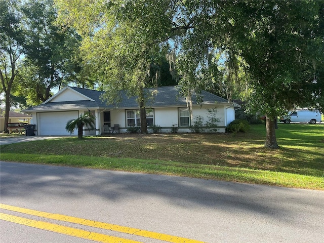 ranch-style home with a garage and a front lawn