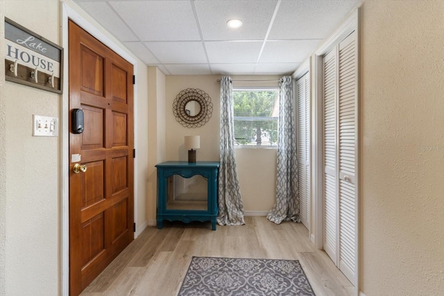 doorway featuring a drop ceiling and light hardwood / wood-style flooring