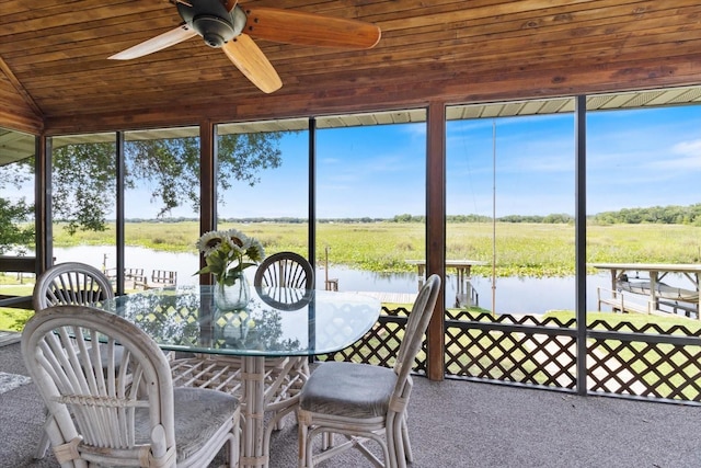 sunroom / solarium with ceiling fan, a water view, wooden ceiling, and plenty of natural light