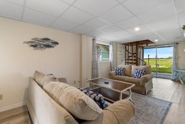 living room featuring a wealth of natural light, light hardwood / wood-style floors, and a paneled ceiling