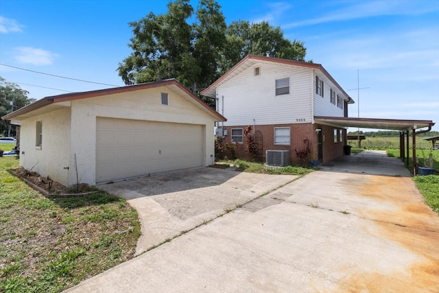 view of property exterior with a carport, central AC unit, a garage, and an outdoor structure