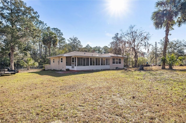 back of property featuring a sunroom and a yard