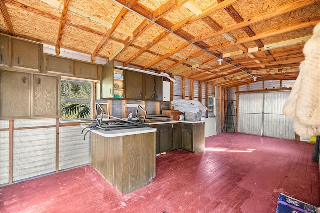 kitchen with dark hardwood / wood-style floors, vaulted ceiling, and kitchen peninsula