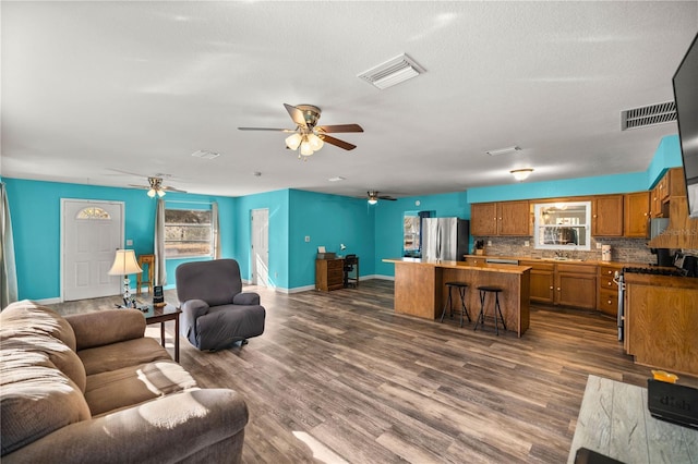 living room with dark hardwood / wood-style flooring, sink, and a textured ceiling