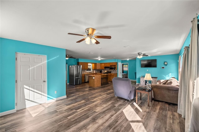 living room with dark wood-type flooring and ceiling fan