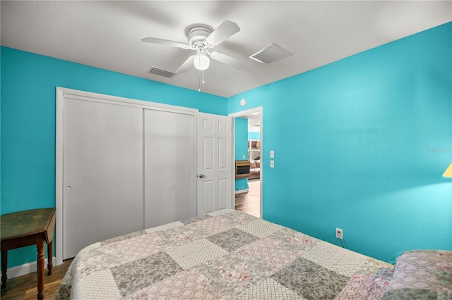 bedroom featuring ceiling fan, hardwood / wood-style floors, and a closet