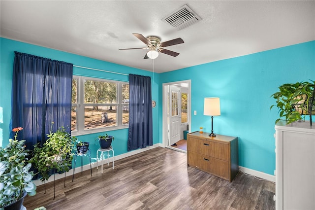 living area with dark hardwood / wood-style flooring, a textured ceiling, and ceiling fan