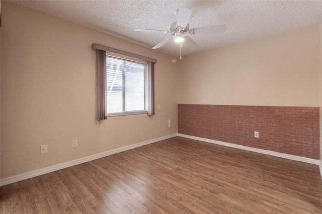 10918 SE 50th Ave, Belleview, FL 34420 - spare room with hardwood / wood-style flooring, brick wall, a textured ceiling, and ceiling fan