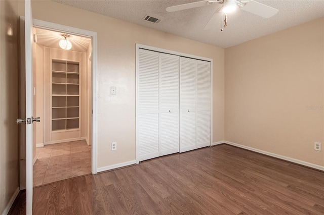 10918 SE 50th Ave, Belleview, FL 34420 - unfurnished bedroom with a textured ceiling, ceiling fan, a closet, and wood-type flooring