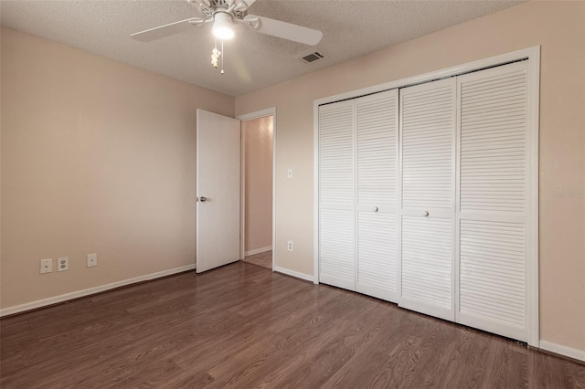 10918 SE 50th Ave, Belleview, FL 34420 - unfurnished bedroom with ceiling fan, a textured ceiling, wood-type flooring, and a closet