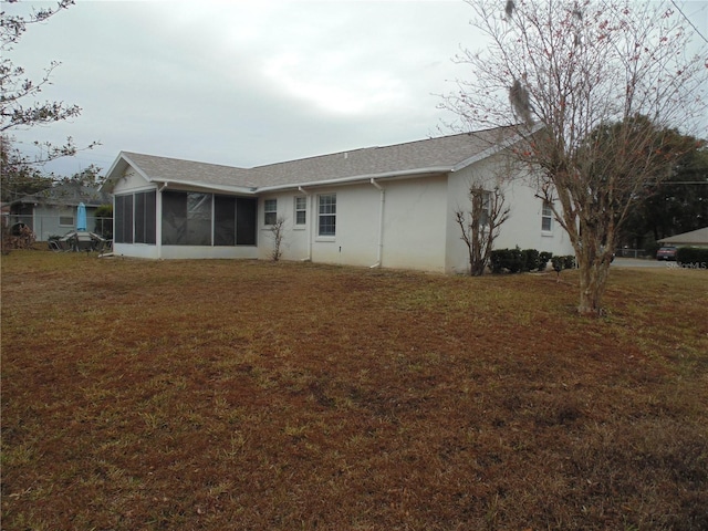 rear view of property featuring a sunroom and a yard