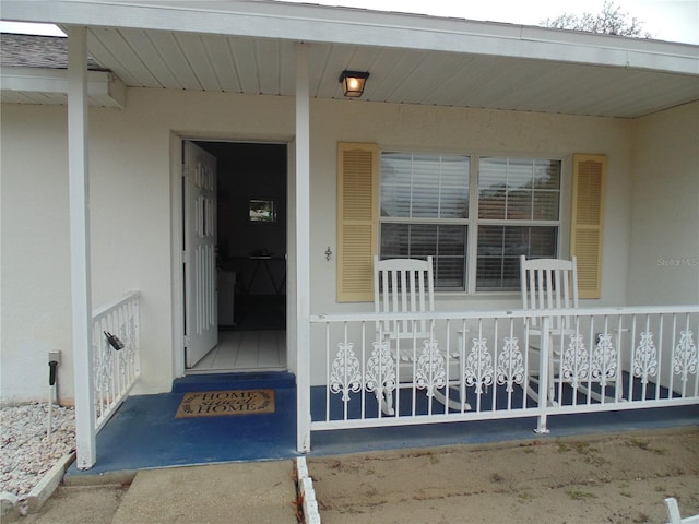 view of exterior entry with covered porch