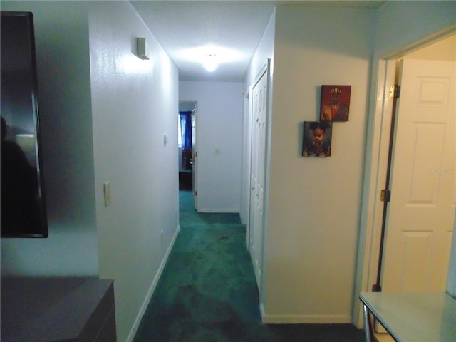 corridor featuring dark colored carpet