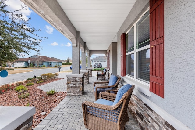 view of patio / terrace featuring a garage and a porch