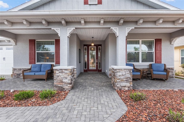 view of exterior entry with covered porch and a garage