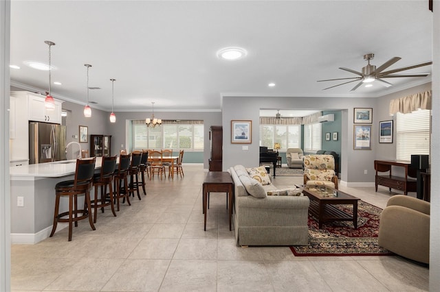 tiled living room with plenty of natural light, ceiling fan with notable chandelier, ornamental molding, and a wall unit AC