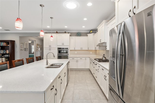 kitchen with decorative light fixtures, white cabinetry, stainless steel appliances, an island with sink, and sink