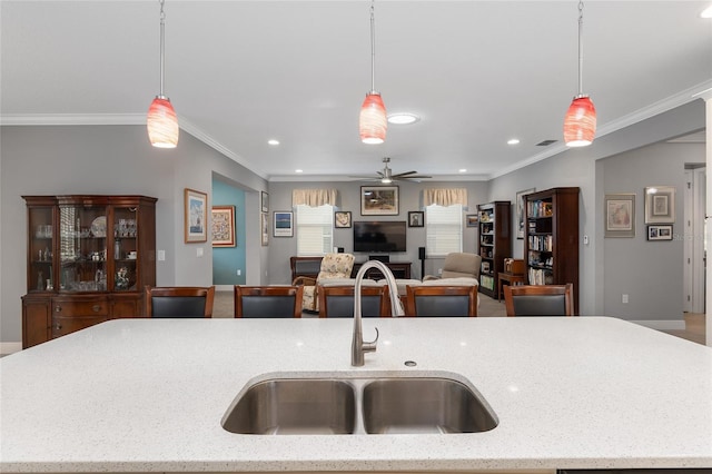 kitchen featuring hanging light fixtures, ceiling fan, and sink