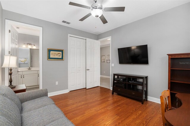 living room with ceiling fan, hardwood / wood-style floors, and sink