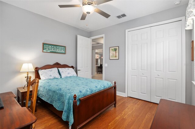 bedroom with ceiling fan, a closet, and wood-type flooring