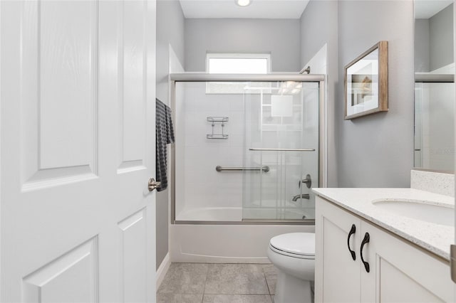 full bathroom with shower / bath combination with glass door, vanity, toilet, and tile patterned flooring