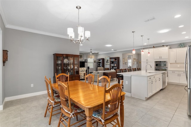 tiled dining room featuring ceiling fan with notable chandelier, sink, and crown molding