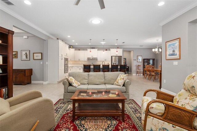 living room with ceiling fan with notable chandelier, crown molding, and light tile patterned flooring