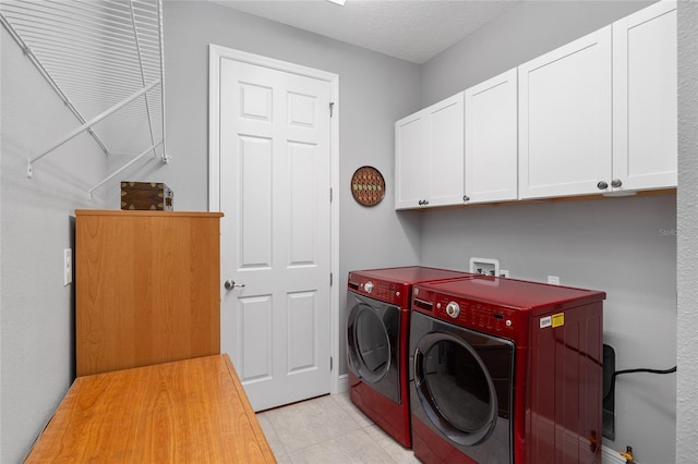 laundry area with washing machine and clothes dryer and cabinets