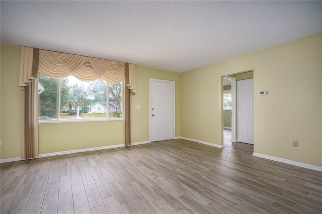 unfurnished room featuring a textured ceiling and hardwood / wood-style flooring