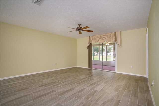 spare room featuring ceiling fan, a textured ceiling, and wood-type flooring