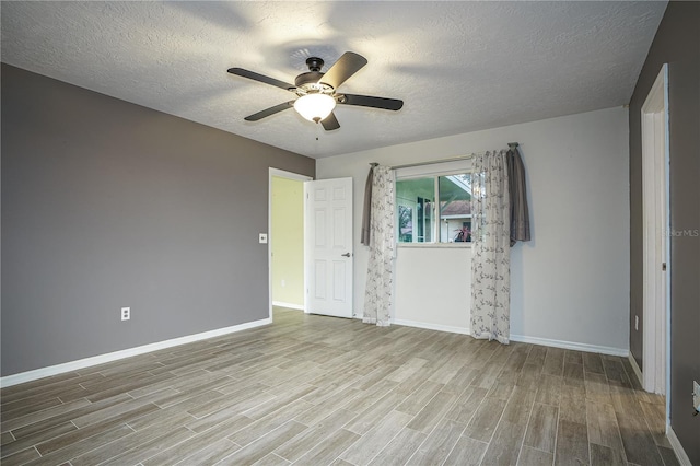 spare room with a textured ceiling, ceiling fan, and light hardwood / wood-style floors