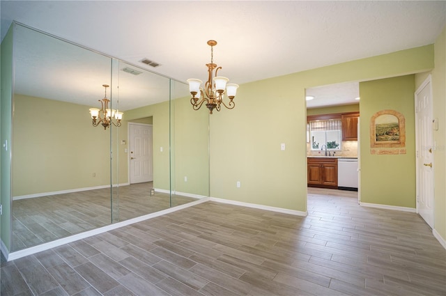 unfurnished room with sink and a notable chandelier