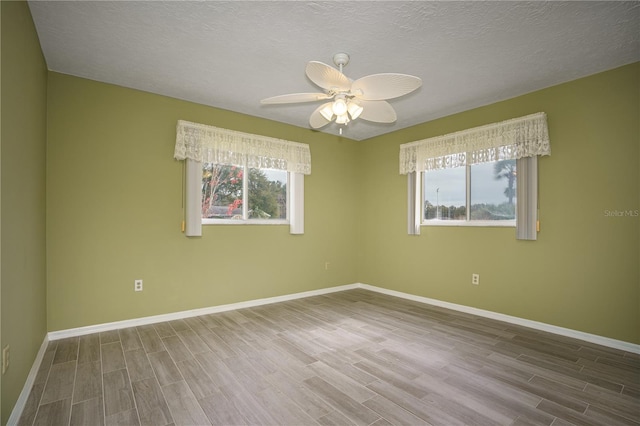 spare room with ceiling fan, a textured ceiling, and hardwood / wood-style floors