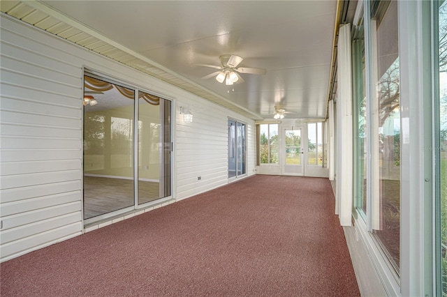 unfurnished sunroom featuring ceiling fan