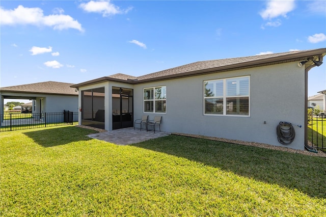 rear view of property featuring a patio area, a sunroom, and a lawn