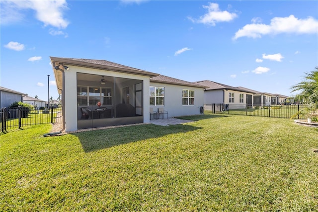 rear view of property with ceiling fan, a sunroom, and a lawn