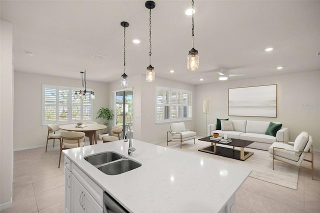 kitchen with sink, pendant lighting, white cabinets, and a kitchen island with sink