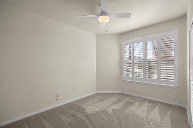 carpeted spare room with ceiling fan and a textured ceiling