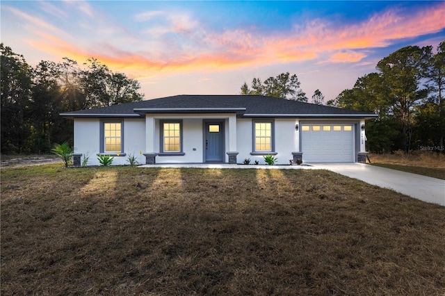 view of front of house featuring covered porch, a yard, and a garage