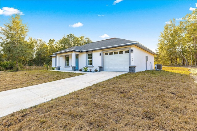 view of front of property with a front lawn, a garage, and central air condition unit