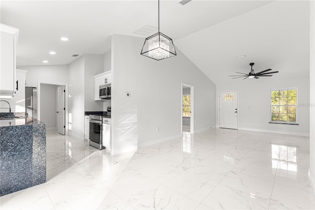 kitchen featuring stainless steel appliances, ceiling fan with notable chandelier, white cabinetry, and sink