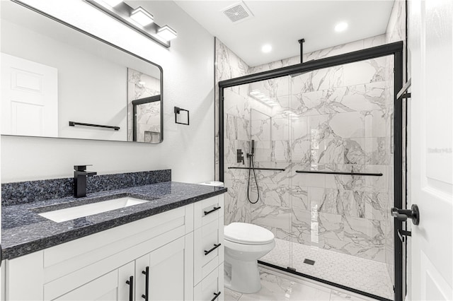 bathroom featuring toilet, a shower with shower door, and vanity