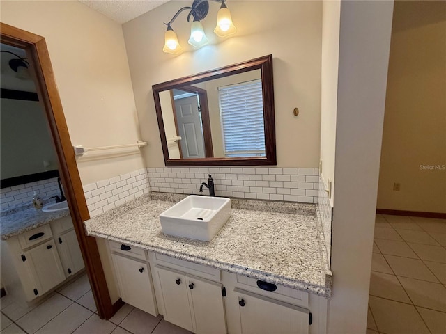 bathroom with a textured ceiling, decorative backsplash, vanity, and tile patterned floors