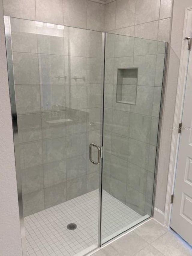 bathroom featuring tile patterned floors and a stall shower