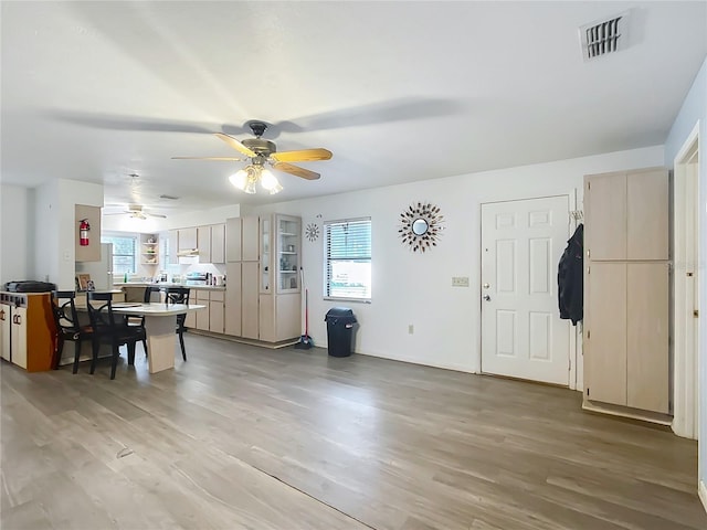 entryway featuring ceiling fan, light wood-type flooring, and a healthy amount of sunlight