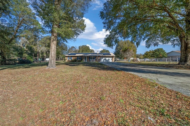 ranch-style home with a garage and a front lawn