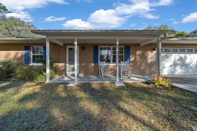 view of front facade featuring a porch, a garage, and a front lawn