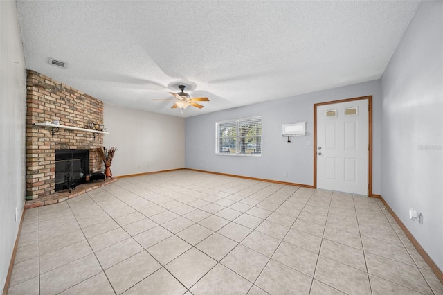 unfurnished living room featuring ceiling fan, a fireplace, a textured ceiling, and light tile patterned floors