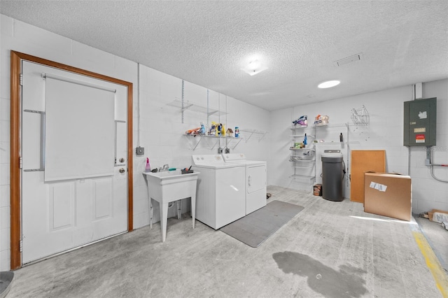 laundry area featuring washer and clothes dryer, electric panel, and a textured ceiling